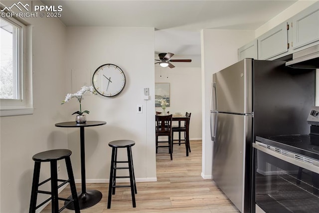 409 Columbine St, Fountain, CO 80817 - kitchen with stainless steel electric range oven, ceiling fan, light wood-style flooring, and baseboards