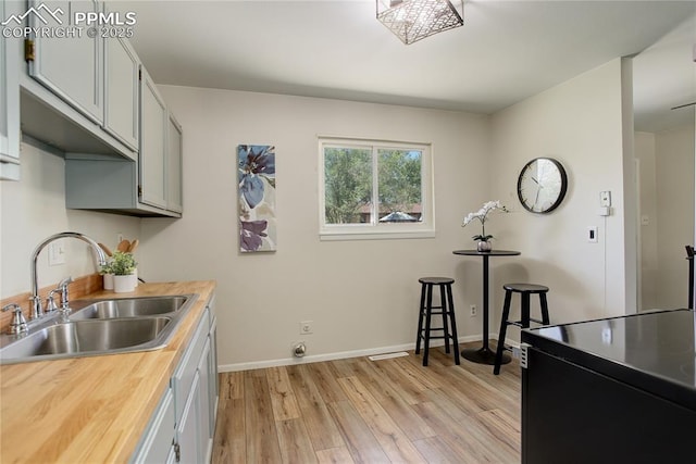 409 Columbine St, Fountain, CO 80817 - kitchen with a sink, light wood-style floors, black electric range oven, butcher block counters, and baseboards