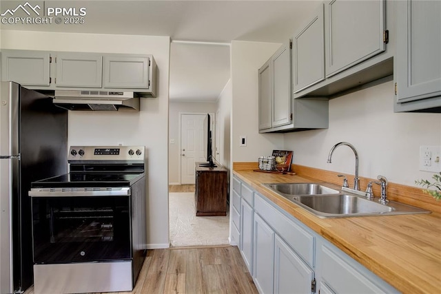 409 Columbine St, Fountain, CO 80817 - kitchen with appliances with stainless steel finishes, under cabinet range hood, a sink, light wood-type flooring, and gray cabinetry