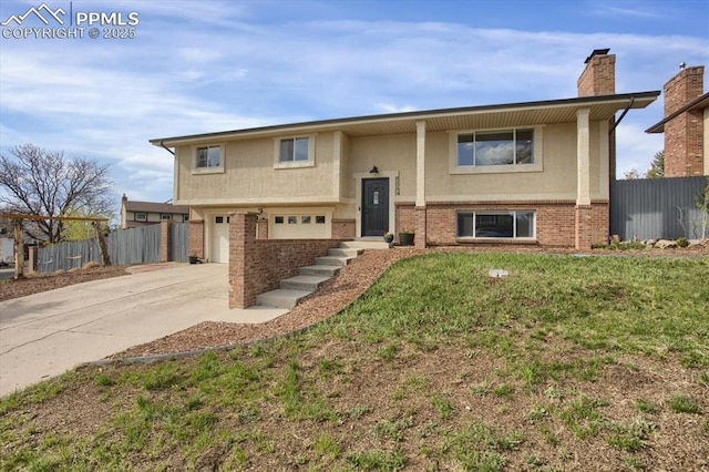 5064 Artistic Cir, Colorado Springs, CO 80917 - raised ranch featuring brick siding, driveway, fence, and stucco siding