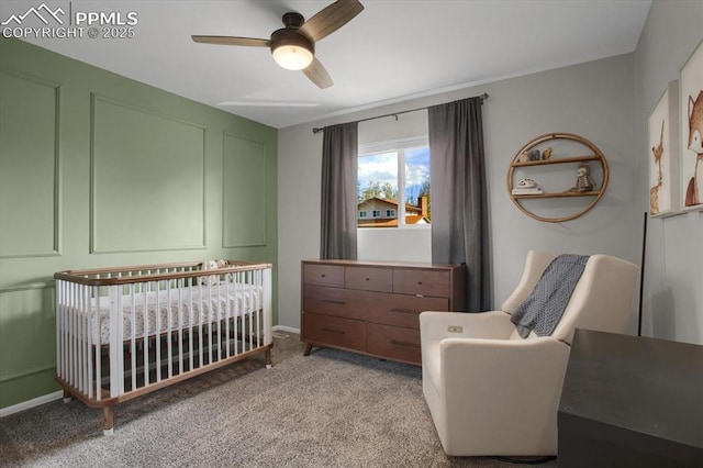 5064 Artistic Cir, Colorado Springs, CO 80917 - bedroom with a crib, ceiling fan, baseboards, and light colored carpet