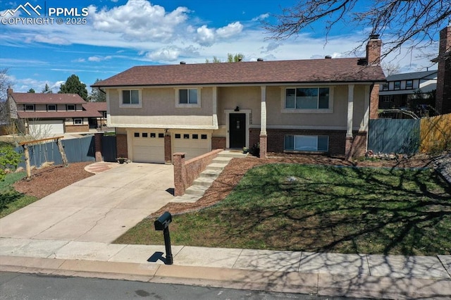 5064 Artistic Cir, Colorado Springs, CO 80917 - split foyer home with a garage, brick siding, fence, concrete driveway, and stucco siding
