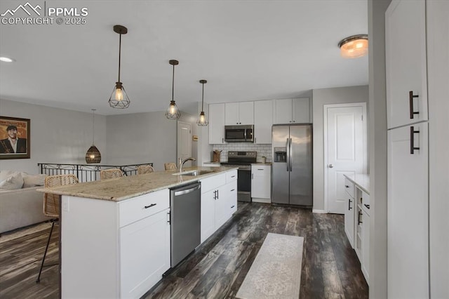 5064 Artistic Cir, Colorado Springs, CO 80917 - kitchen featuring open floor plan, a kitchen breakfast bar, dark wood-style floors, a sink, and appliances with stainless steel finishes