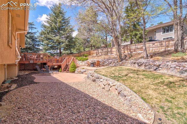 view of yard with a patio area, a fenced backyard, and a deck