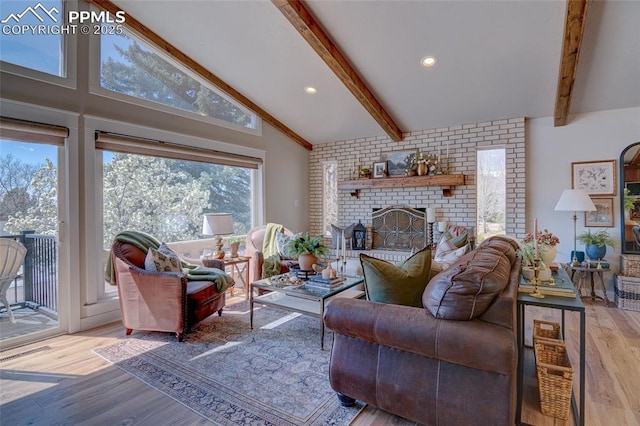 living area with high vaulted ceiling, a fireplace, beam ceiling, and light wood-style floors