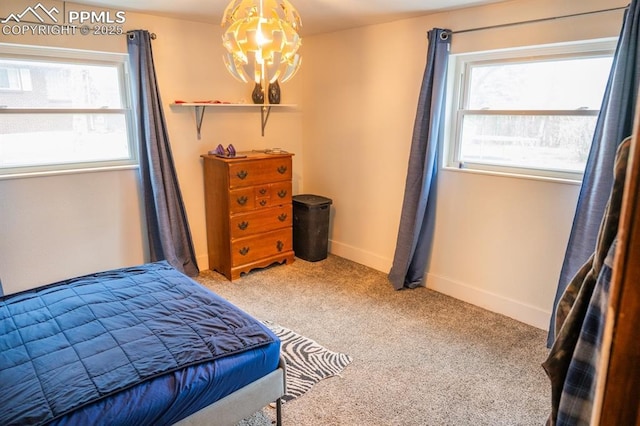 bedroom featuring baseboards, carpet, a notable chandelier, and multiple windows