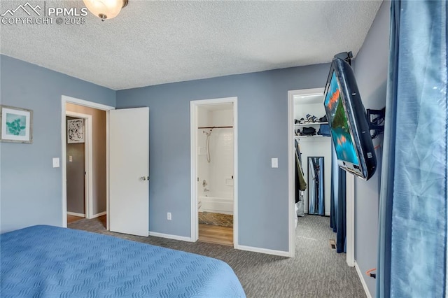 4230 Hollow Rd, Colorado Springs, CO 80917 - bedroom with a textured ceiling, baseboards, a spacious closet, ensuite bathroom, and carpet flooring
