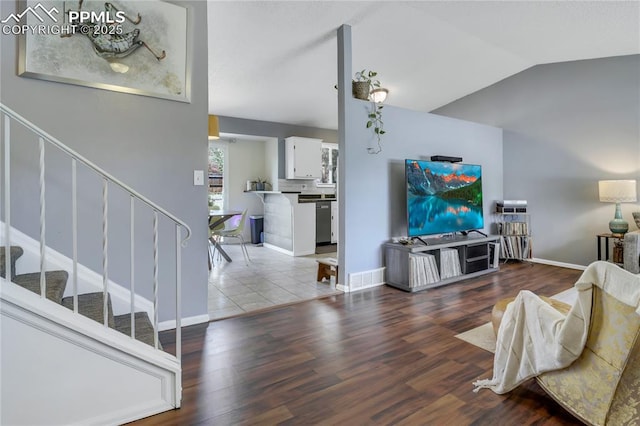4230 Hollow Rd, Colorado Springs, CO 80917 - living room with wood finished floors, lofted ceiling, visible vents, and stairway