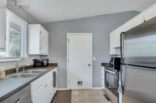 4230 Hollow Rd, Colorado Springs, CO 80917 - kitchen with a sink, appliances with stainless steel finishes, dark countertops, and white cabinetry