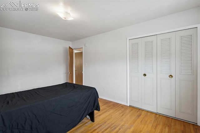 bedroom with a closet, baseboards, and light wood-type flooring