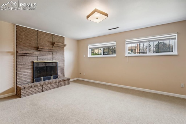 unfurnished living room with baseboards, visible vents, carpet floors, and a brick fireplace