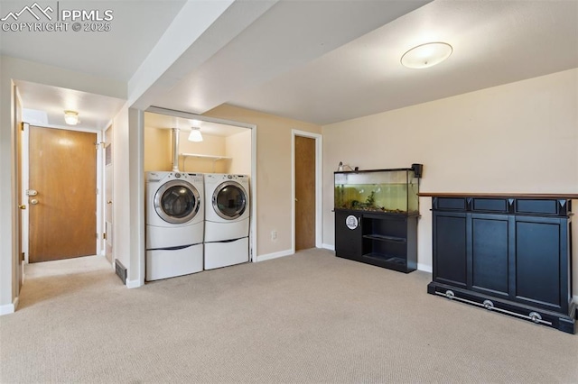 laundry area featuring washing machine and clothes dryer, light carpet, and baseboards
