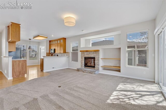 16850 Buffalo Valley Path, Monument, CO 81032 - unfurnished living room featuring light colored carpet, visible vents, built in features, and baseboards