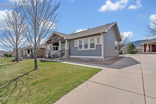 16850 Buffalo Valley Path, Monument, CO 81032 - view of front of home with a porch, a front yard, driveway, and roof with shingles