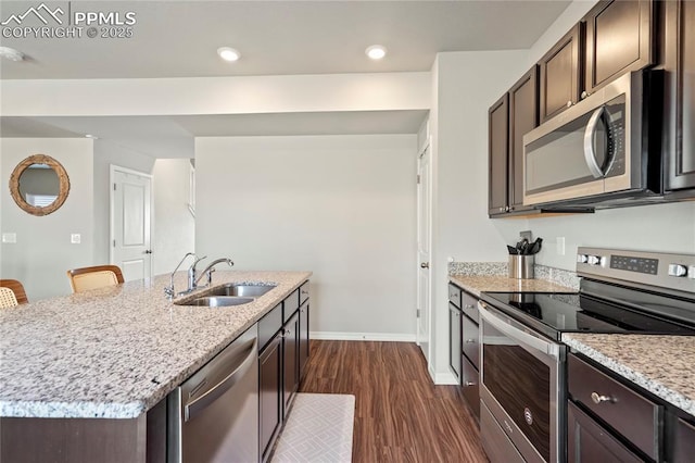 kitchen with a sink, dark brown cabinetry, stainless steel appliances, baseboards, and dark wood-style floors