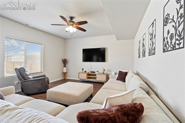 living room with visible vents, wood finished floors, baseboards, and ceiling fan