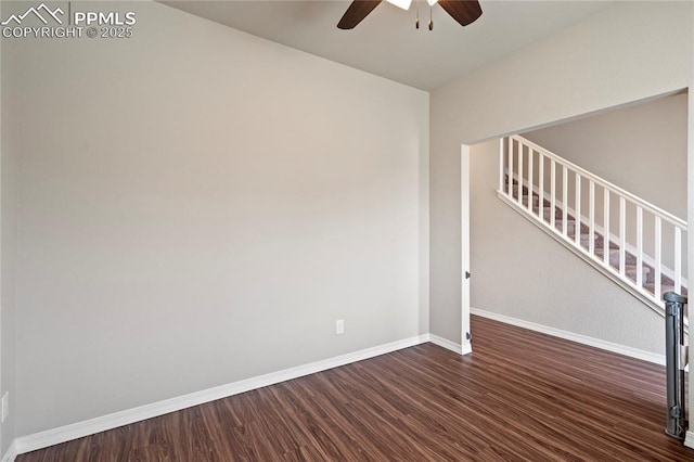 spare room featuring dark wood finished floors, stairway, a ceiling fan, and baseboards