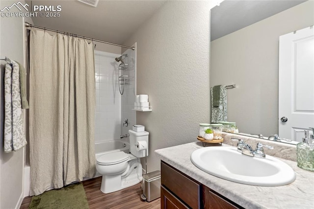 bathroom featuring shower / bath combination with curtain, wood finished floors, toilet, vanity, and baseboards
