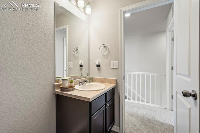 bathroom with a textured wall and vanity