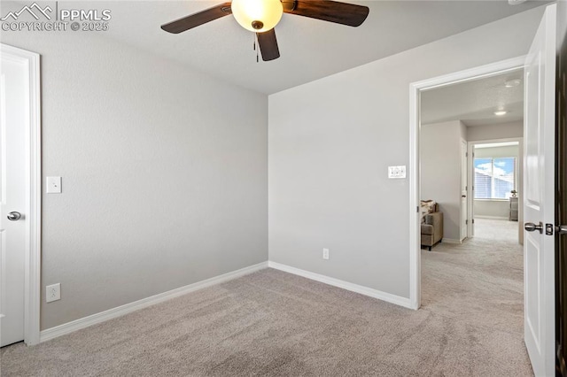 spare room featuring ceiling fan, baseboards, and light carpet