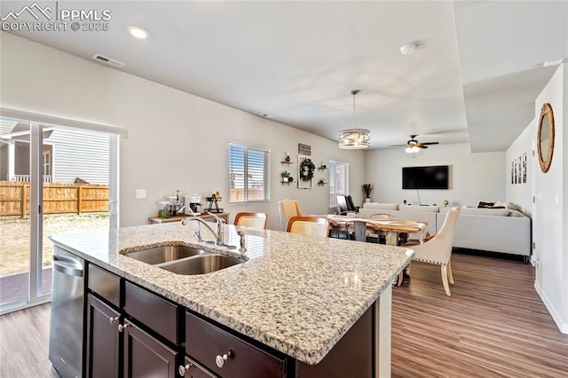 kitchen with a sink, open floor plan, light wood-style floors, ceiling fan, and visible vents