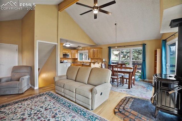 555 Elfin Glen Dr, Divide, CO 80814 - living area with ceiling fan, light wood-style floors, high vaulted ceiling, beam ceiling, and a wood stove