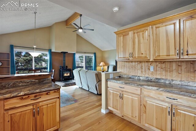555 Elfin Glen Dr, Divide, CO 80814 - kitchen featuring a wood stove, ceiling fan, light wood-style floors, light brown cabinetry, and open floor plan