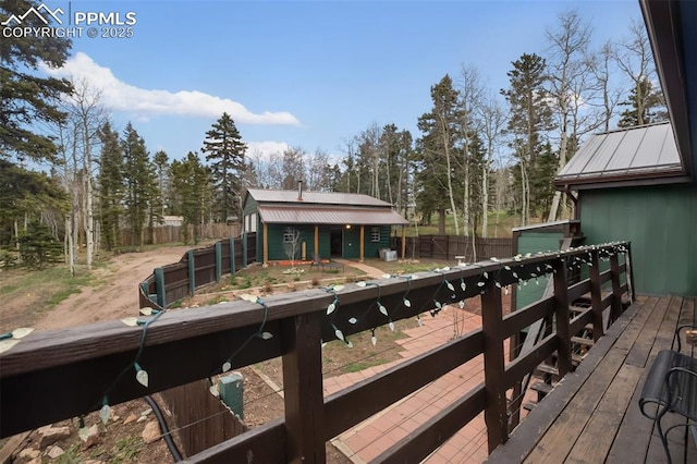 555 Elfin Glen Dr, Divide, CO 80814 - wooden deck featuring an outdoor structure, fence, and view of wooded area