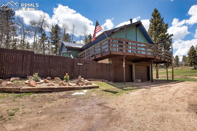 555 Elfin Glen Dr, Divide, CO 80814 - view of property exterior featuring an attached garage, driveway, fence, and a deck