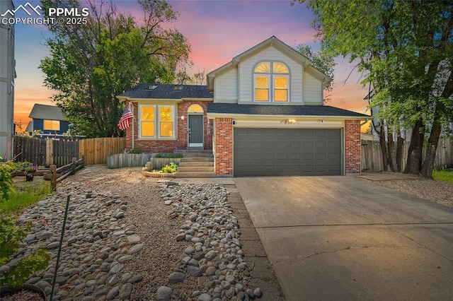 8545 Salsifa Ter, Colorado Springs, CO 80920 - view of front facade with a garage, driveway, brick siding, and a shingled roof