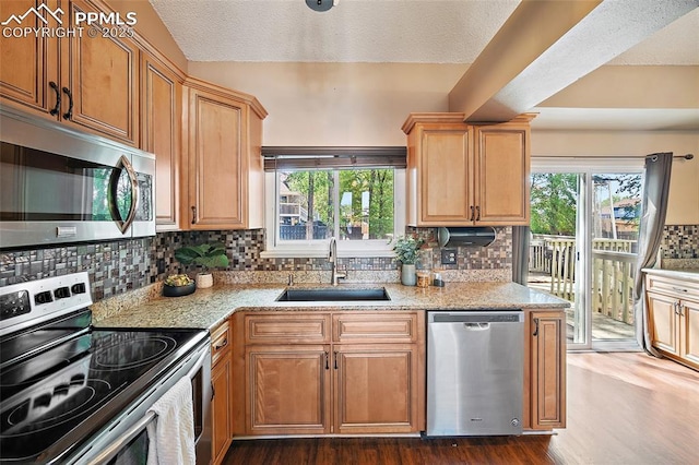 8545 Salsifa Ter, Colorado Springs, CO 80920 - kitchen with appliances with stainless steel finishes, a sink, dark wood-style floors, backsplash, and a textured ceiling