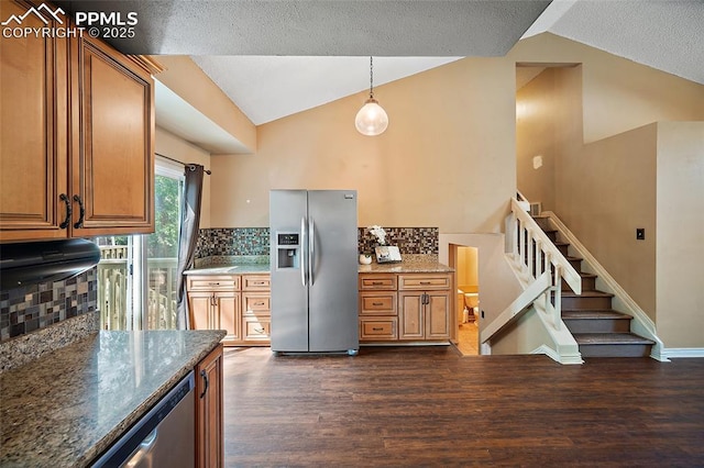 8545 Salsifa Ter, Colorado Springs, CO 80920 - kitchen featuring stainless steel appliances, lofted ceiling, dark wood-style flooring, decorative backsplash, and brown cabinetry