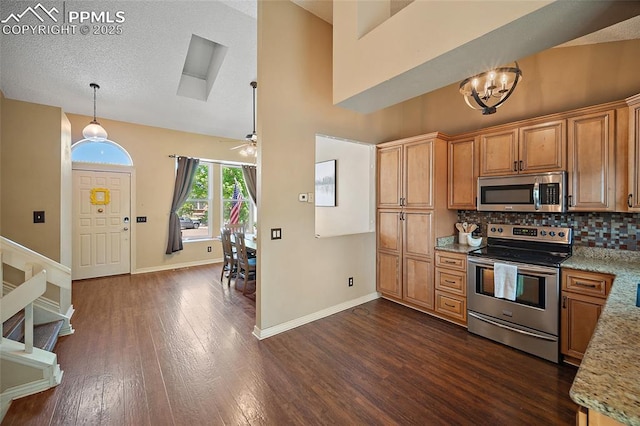 8545 Salsifa Ter, Colorado Springs, CO 80920 - kitchen with stainless steel appliances, dark wood-style flooring, a chandelier, backsplash, and baseboards