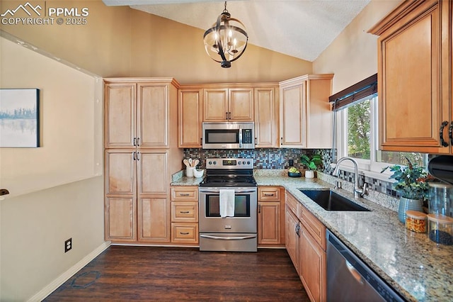 8545 Salsifa Ter, Colorado Springs, CO 80920 - kitchen with appliances with stainless steel finishes, a sink, lofted ceiling, decorative backsplash, and light stone countertops