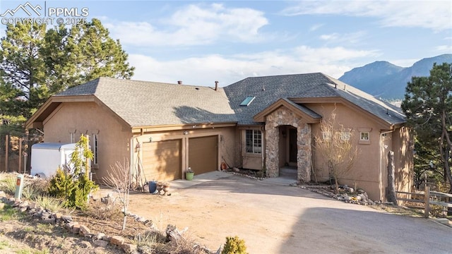 126 Star View Cir, Palmer Lake, CO 80133 - view of front of home with a garage, a mountain view, stone siding, stucco siding, and fence