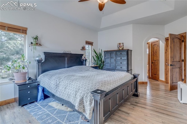 126 Star View Cir, Palmer Lake, CO 80133 - bedroom with a raised ceiling, light wood-style floors, baseboards, and arched walkways