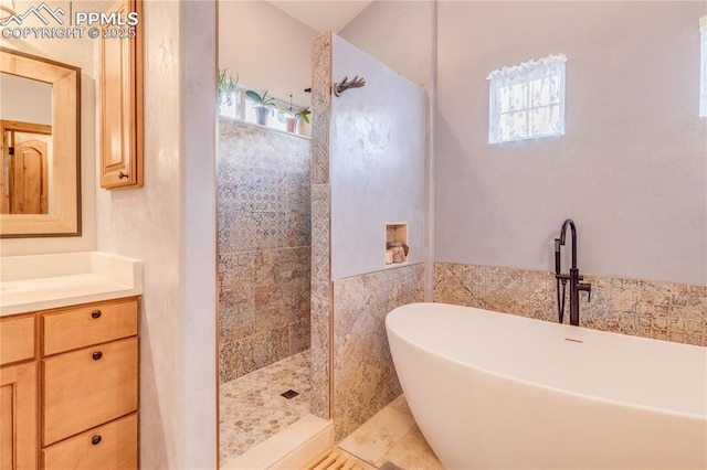 126 Star View Cir, Palmer Lake, CO 80133 - bathroom with walk in shower, tile walls, a freestanding bath, and vanity