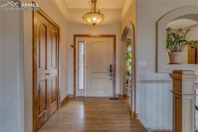 126 Star View Cir, Palmer Lake, CO 80133 - entryway with wood finished floors, baseboards, visible vents, and arched walkways