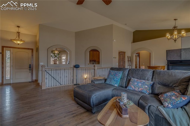 126 Star View Cir, Palmer Lake, CO 80133 - living area with wood finished floors, arched walkways, plenty of natural light, ceiling fan with notable chandelier, and lofted ceiling