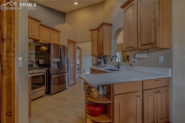 126 Star View Cir, Palmer Lake, CO 80133 - kitchen with arched walkways, light wood-style flooring, open shelves, appliances with stainless steel finishes, and a sink