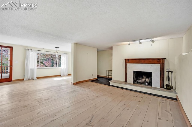 1624 Cheyenne Blvd, Colorado Springs, CO 80906 - unfurnished living room featuring wood-type flooring, a textured ceiling, plenty of natural light, and a fireplace