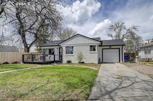 single story home featuring a front yard, driveway, a deck, an attached garage, and fence