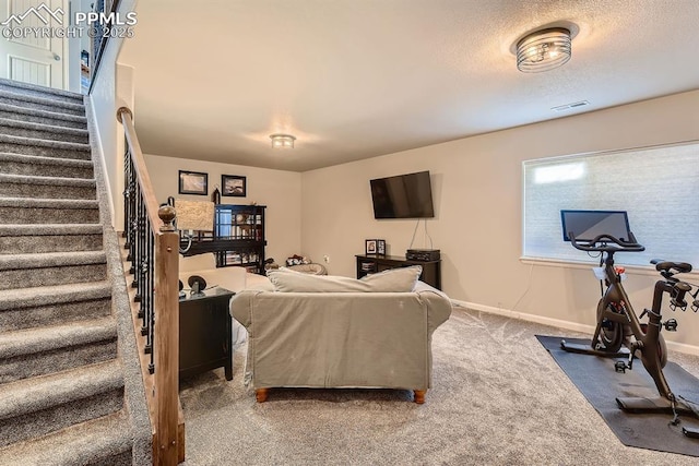 living area featuring carpet flooring, a textured ceiling, stairs, baseboards, and visible vents