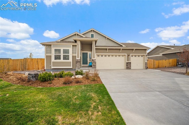 craftsman-style home with fence, a front lawn, concrete driveway, and an attached garage