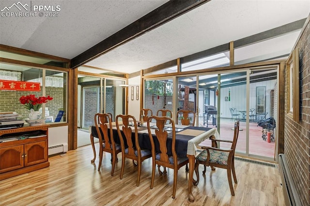 dining area featuring floor to ceiling windows, baseboard heating, light wood-type flooring, beam ceiling, and a baseboard heating unit