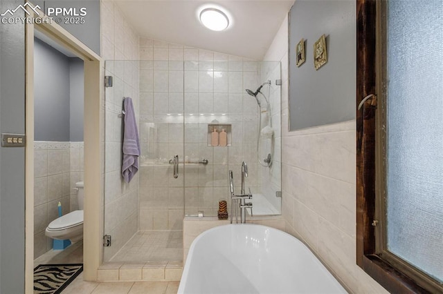 full bathroom with a freestanding tub, tile walls, and a stall shower