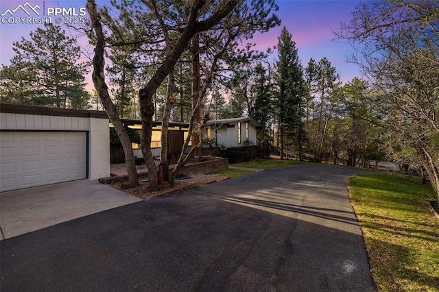 view of front facade featuring a garage and aphalt driveway