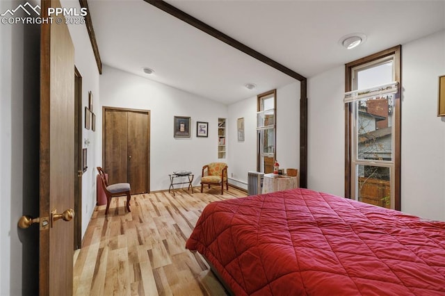 bedroom with vaulted ceiling and light wood-type flooring