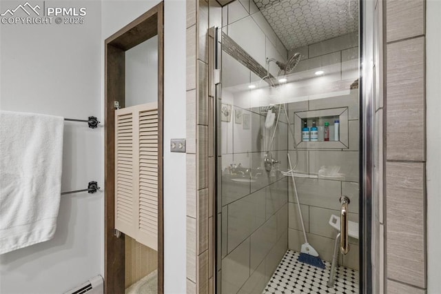 full bath with a shower stall and a baseboard radiator