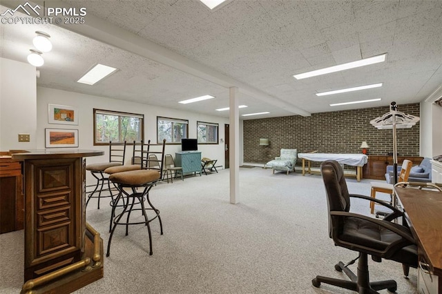 home office featuring carpet floors and brick wall